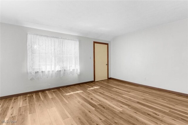 spare room with light hardwood / wood-style flooring