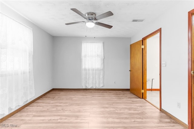 spare room featuring light hardwood / wood-style flooring and ceiling fan