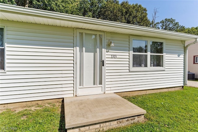 property entrance with a yard and central air condition unit