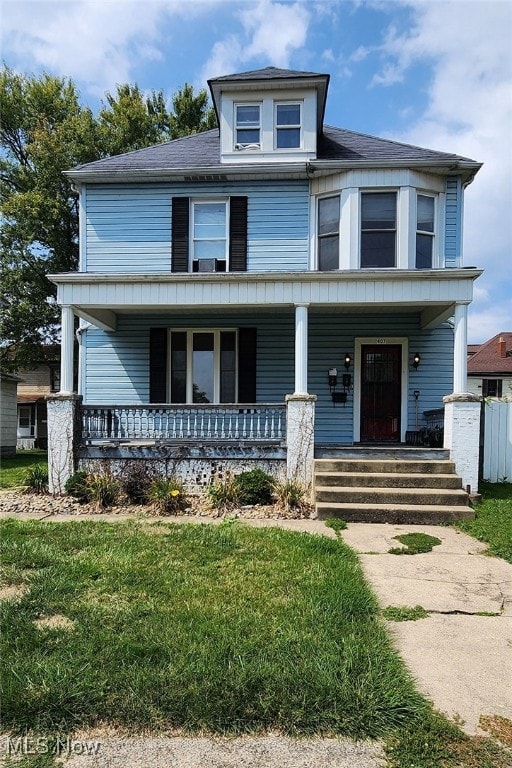 view of front of property with covered porch and a front yard