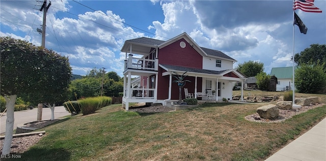 view of front of property featuring a balcony, a front yard, and a porch