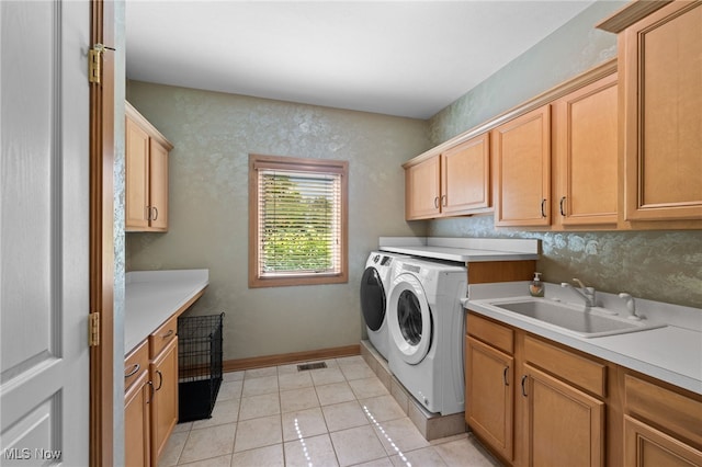 laundry room featuring washer and clothes dryer, light tile patterned floors, cabinets, and sink