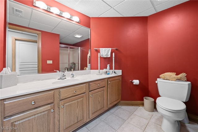 bathroom featuring an enclosed shower, tile patterned floors, toilet, a drop ceiling, and vanity