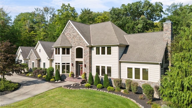 view of front of house with a balcony and a front yard