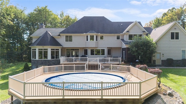 back of house featuring a pool side deck and a lawn