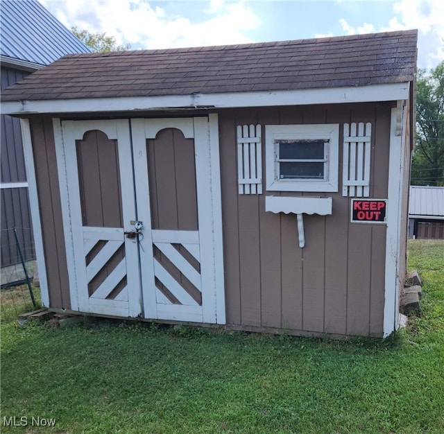 view of outbuilding featuring a lawn