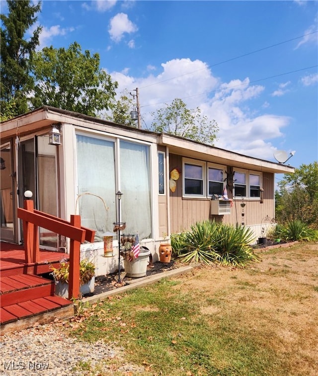 view of front facade with a wooden deck and a front lawn