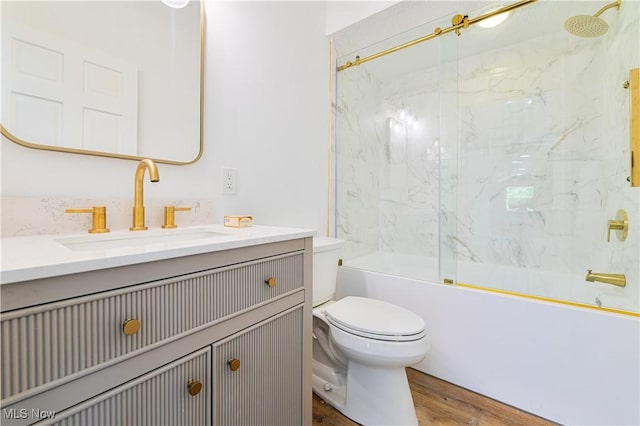 full bathroom featuring hardwood / wood-style floors, vanity, enclosed tub / shower combo, and toilet