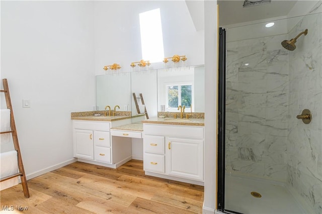 bathroom featuring a tile shower, vanity, and hardwood / wood-style flooring