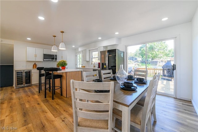 dining room with beverage cooler and light wood-type flooring