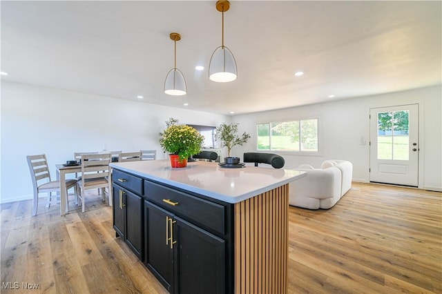 kitchen with pendant lighting, a center island, light hardwood / wood-style floors, and plenty of natural light