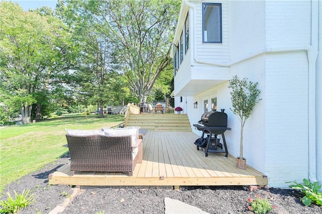 wooden terrace featuring area for grilling and a yard