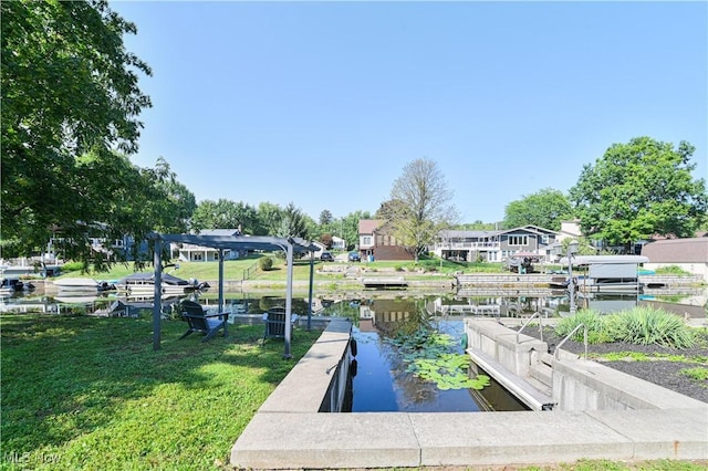 view of dock with a yard and a water view