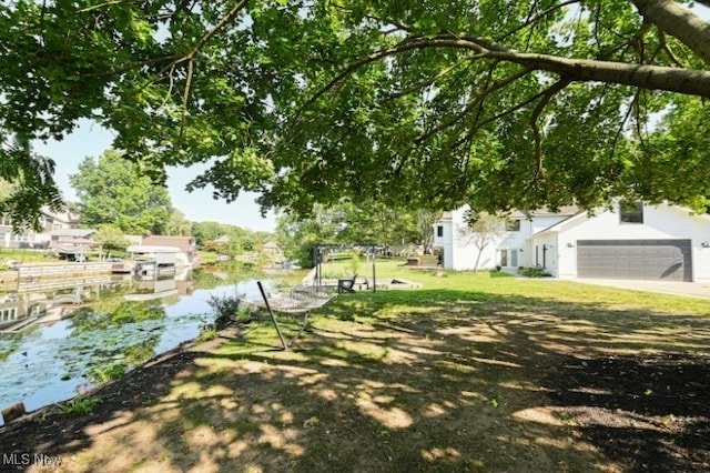 view of yard featuring a garage and a water view