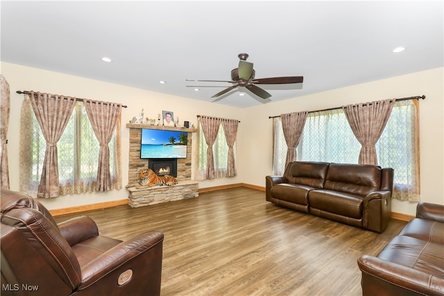 living room with ceiling fan, hardwood / wood-style floors, and a fireplace