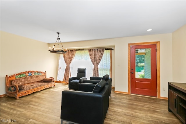 living room featuring wood-type flooring, a wealth of natural light, and an inviting chandelier