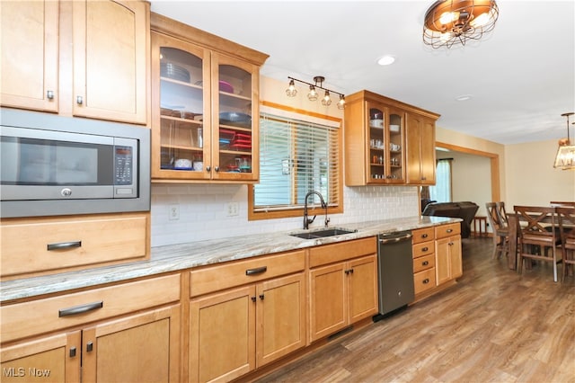 kitchen with light stone counters, stainless steel appliances, light hardwood / wood-style flooring, and sink