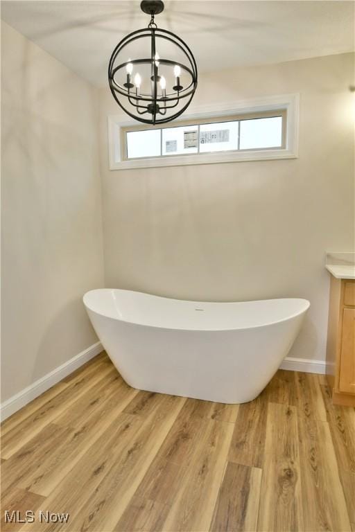 bathroom with vanity, a bathtub, wood-type flooring, and a chandelier