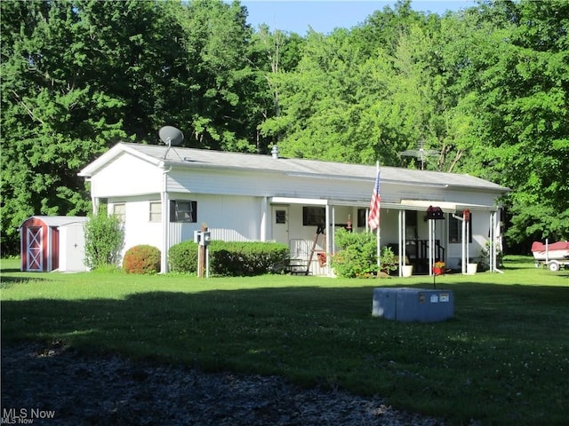 single story home with a porch, a storage shed, and a front yard