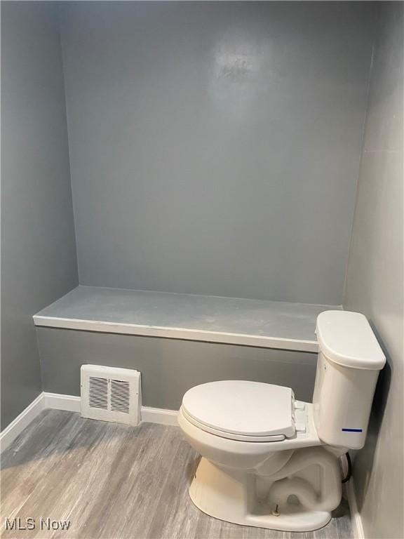 bathroom with hardwood / wood-style floors and toilet