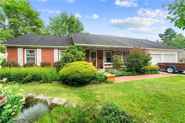 ranch-style house featuring covered porch, a garage, and a front lawn