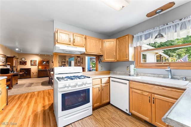 kitchen featuring sink, kitchen peninsula, pendant lighting, white appliances, and light hardwood / wood-style floors