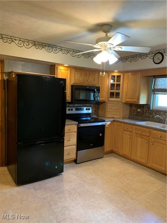 kitchen featuring decorative backsplash, light tile patterned flooring, black appliances, ceiling fan, and sink