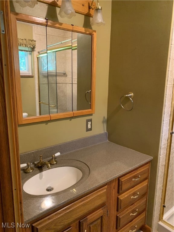 bathroom with vanity and a shower with shower door