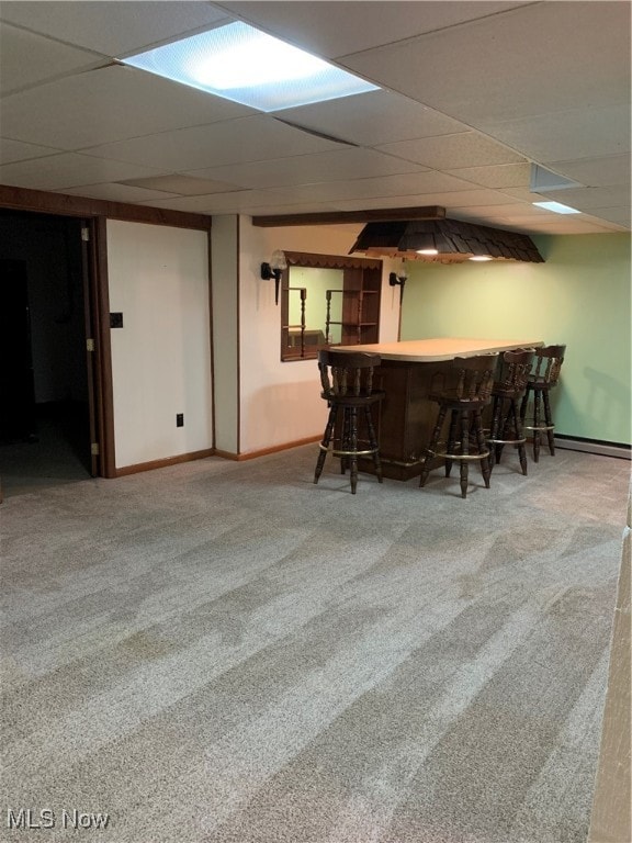 bar featuring a drop ceiling, baseboard heating, and carpet flooring