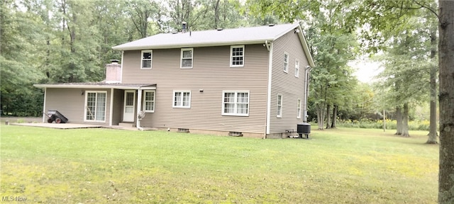 rear view of house featuring a lawn and a patio area