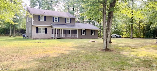 view of front of house with a sunroom, a front lawn, and central AC unit