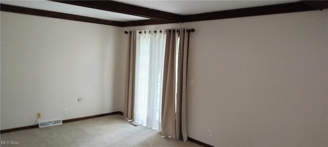 carpeted empty room featuring beam ceiling