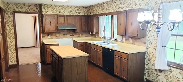 kitchen featuring dishwasher, a kitchen island, sink, and wood counters