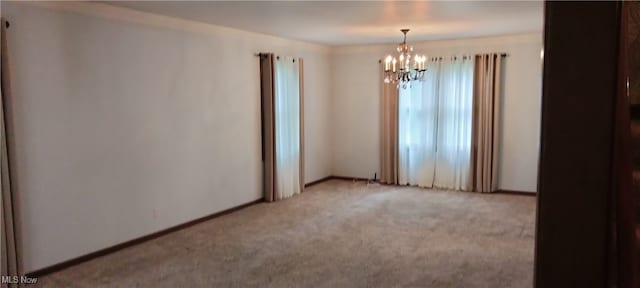 carpeted empty room with a chandelier