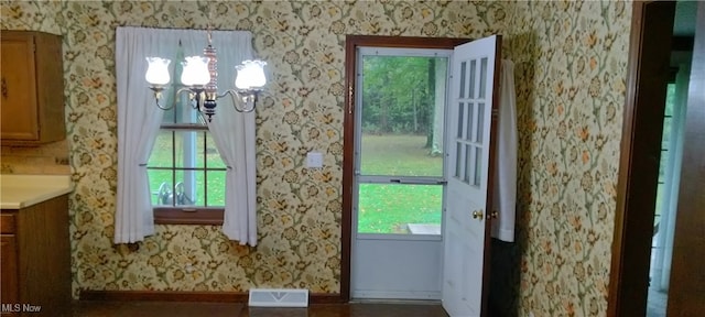 doorway to outside with a chandelier and a healthy amount of sunlight