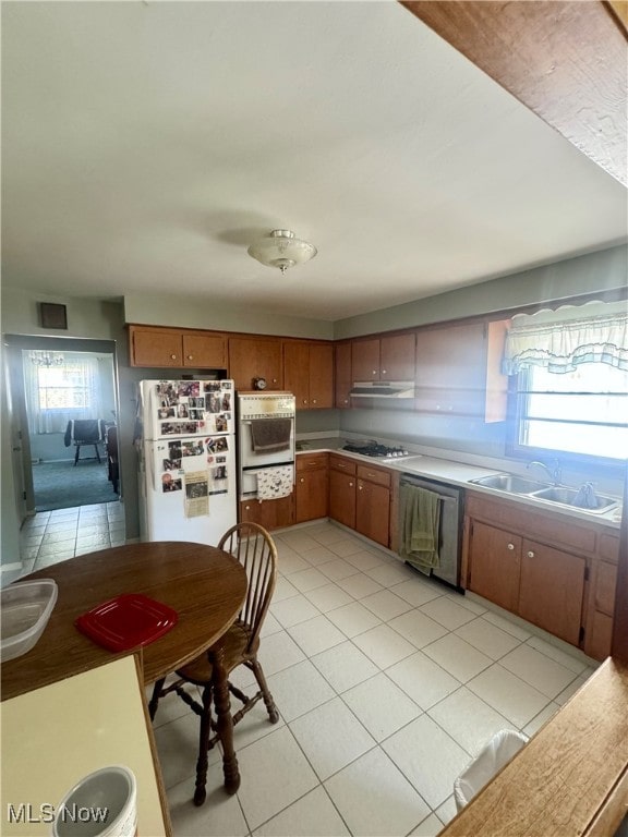 kitchen with sink, white appliances, and light tile patterned flooring