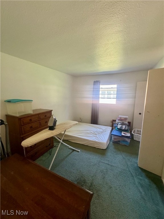 bedroom with a textured ceiling and carpet floors