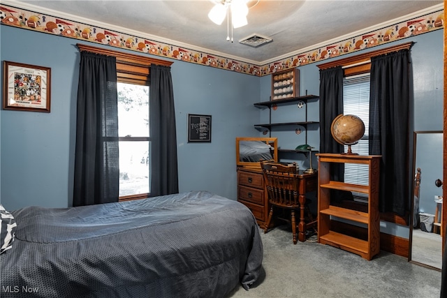 bedroom with a textured ceiling, ceiling fan, ornamental molding, and light carpet