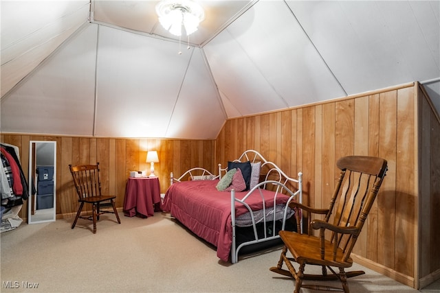 carpeted bedroom featuring vaulted ceiling and wooden walls