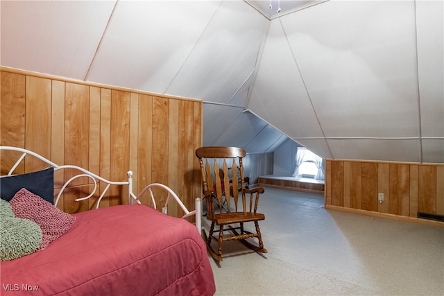 carpeted bedroom with lofted ceiling and wooden walls