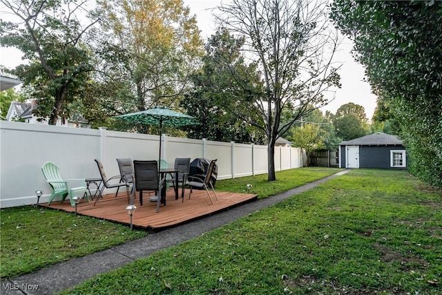 view of yard featuring a wooden deck and a storage shed