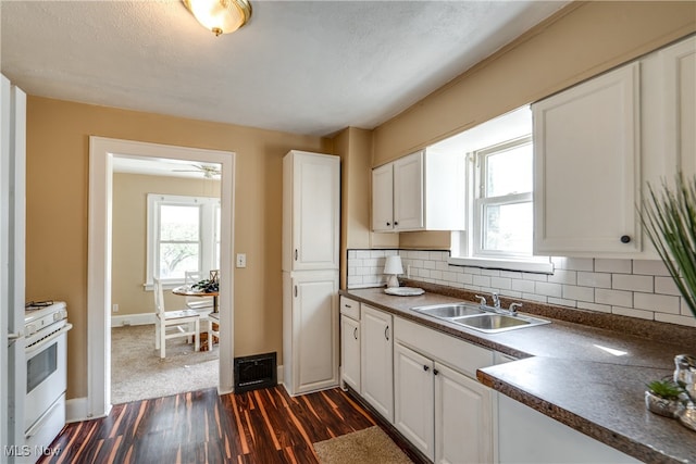 kitchen with white range with gas stovetop, a wealth of natural light, dark hardwood / wood-style floors, and sink