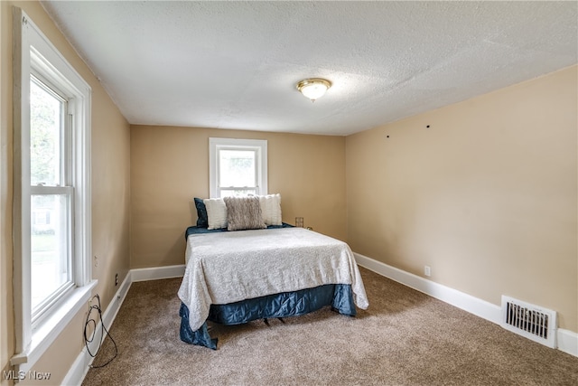 bedroom featuring a textured ceiling and carpet floors