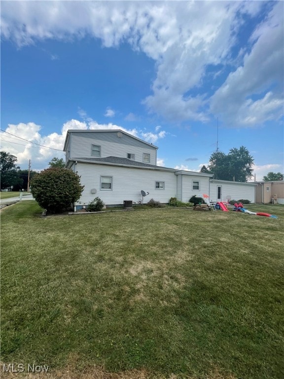 view of side of home with a yard and central air condition unit