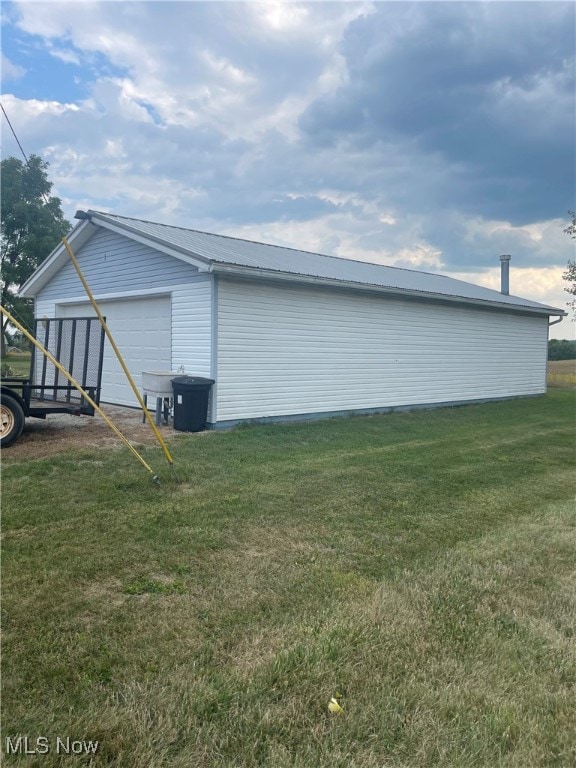 view of side of home featuring a lawn and a garage