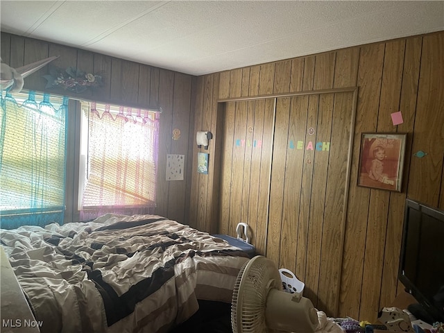 bedroom featuring wood walls