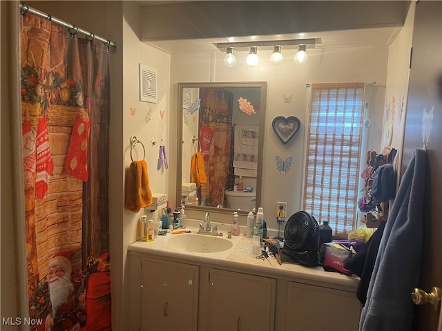 bathroom with vanity, toilet, and curtained shower