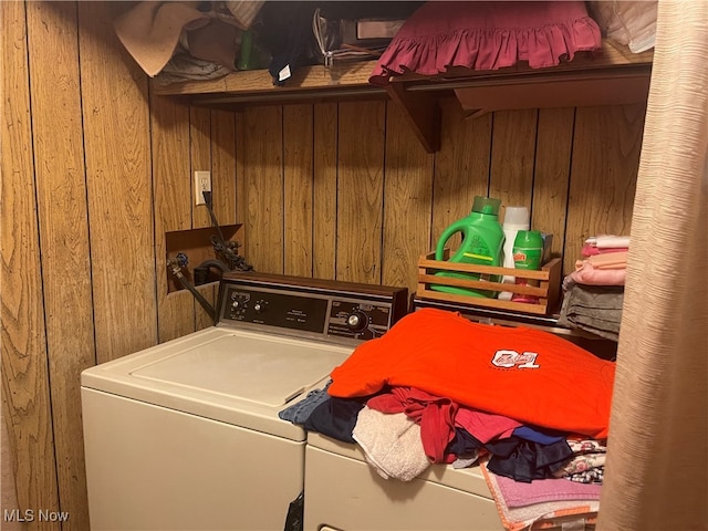 washroom with wood walls and washer and clothes dryer