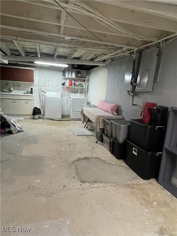 basement with washing machine and clothes dryer and electric panel