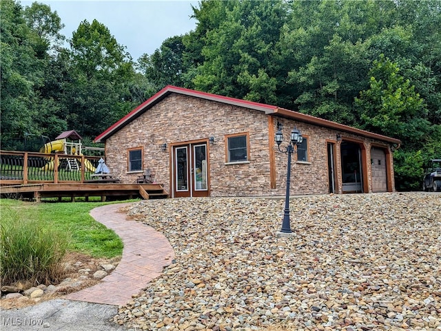 view of side of home with a wooden deck and french doors